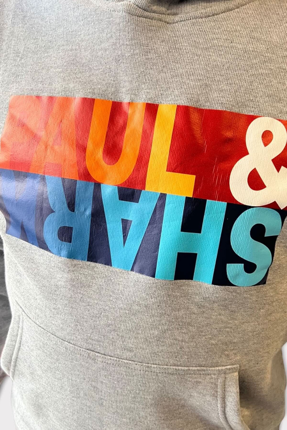 Coton ouaté Paul and Shark avec logo coloré sur un tissu gris, parfait pour le printemps.