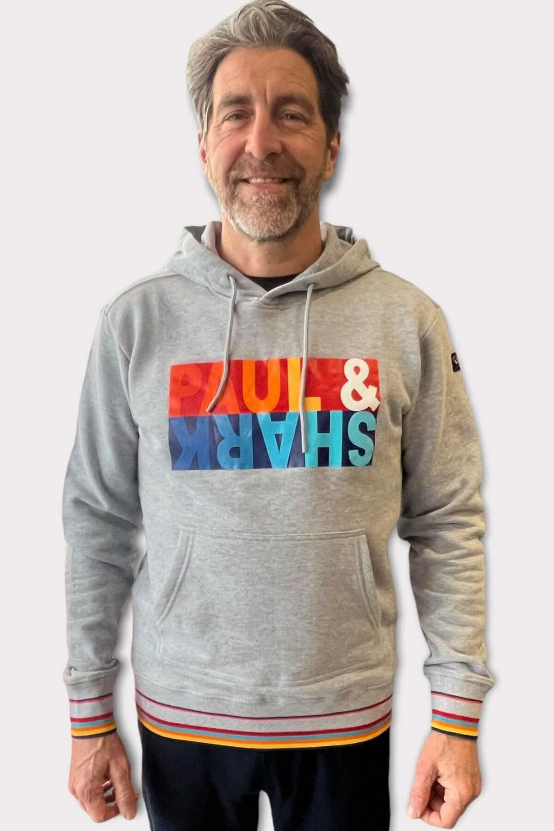 Homme portant un coton ouaté gris avec logo coloré Paul & Shark, idéal pour les journées froides de printemps.