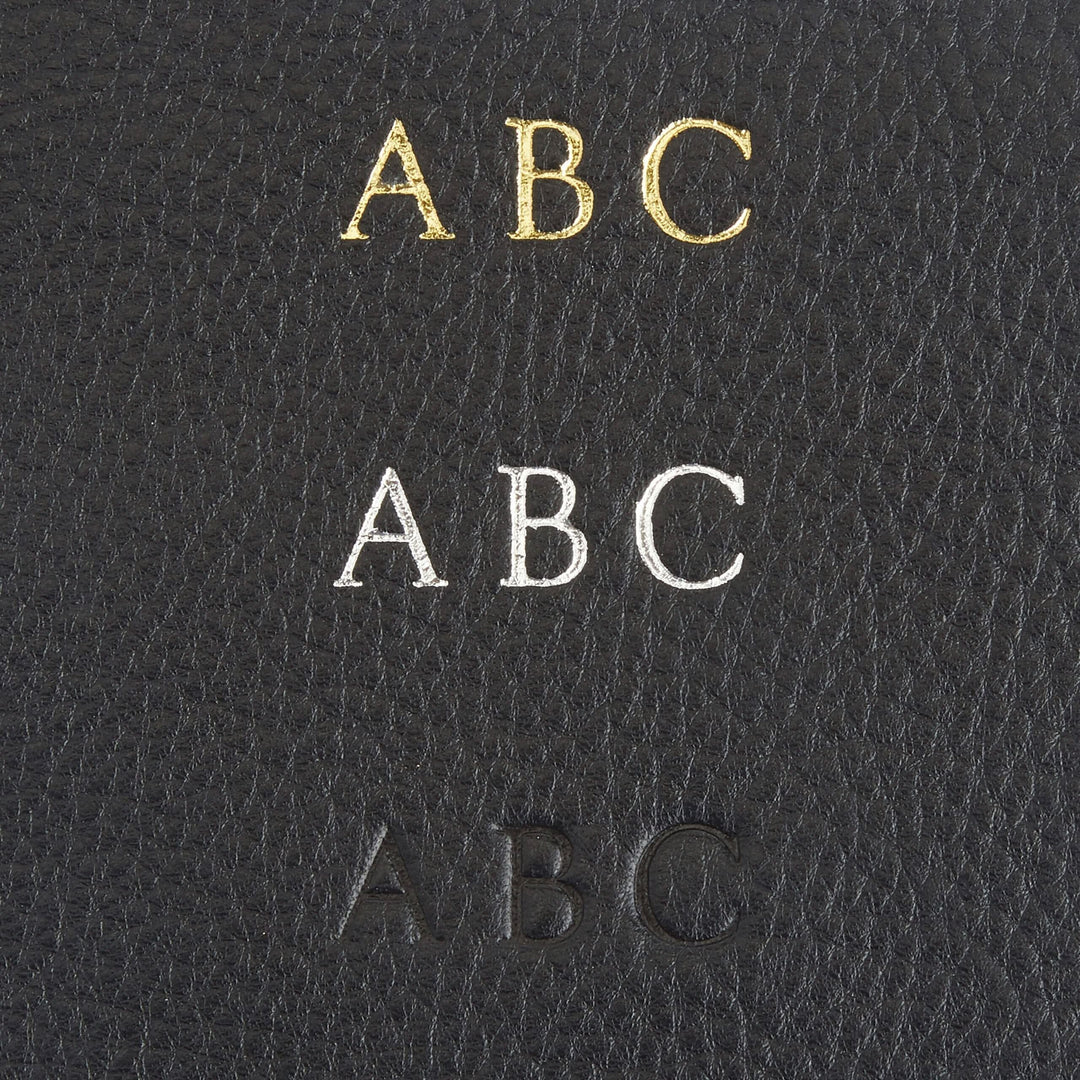 Monogram personalization options in gold, silver, and blind embossing on black leather for a custom wallet.