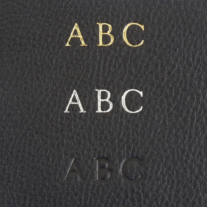 Monogrammed leather wallet showing initials ABC in gold, silver, and embossed black on full grain leather.