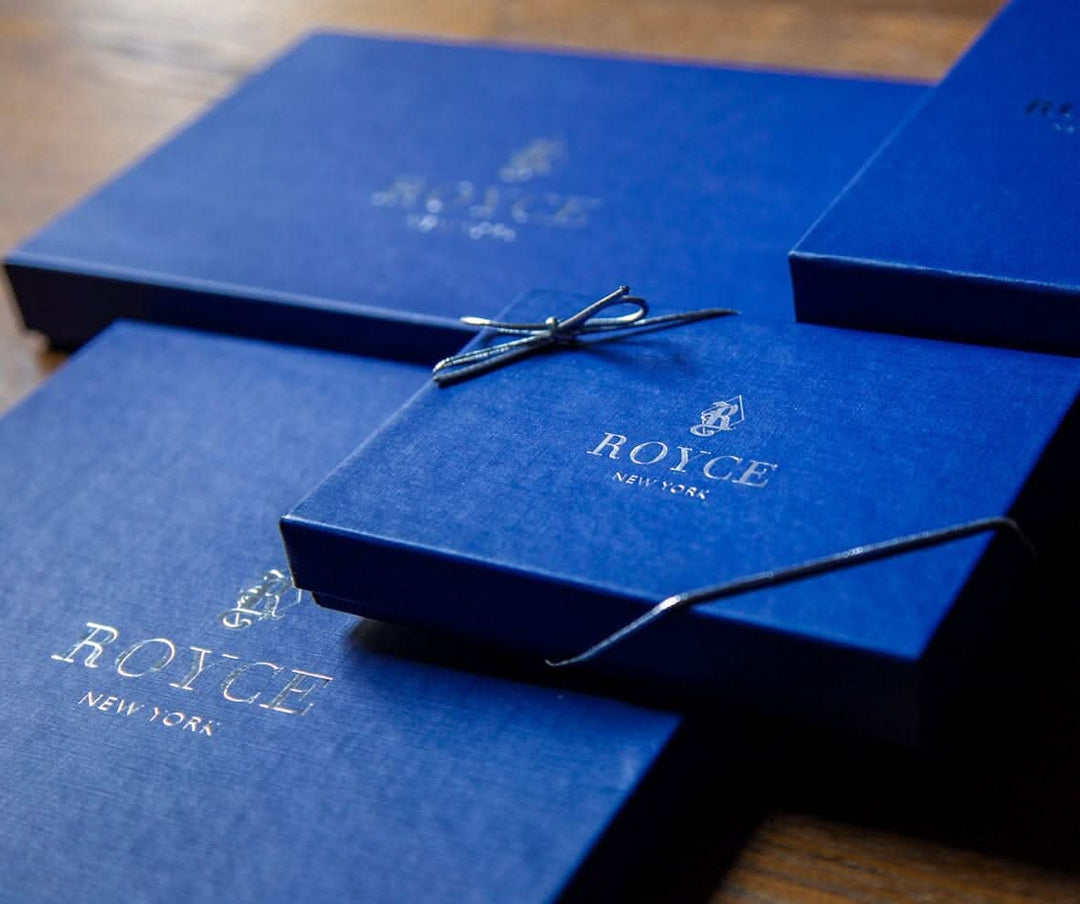 Elegant ROYCE New York gift boxes in deep blue, perfect for presenting luxury leather products.