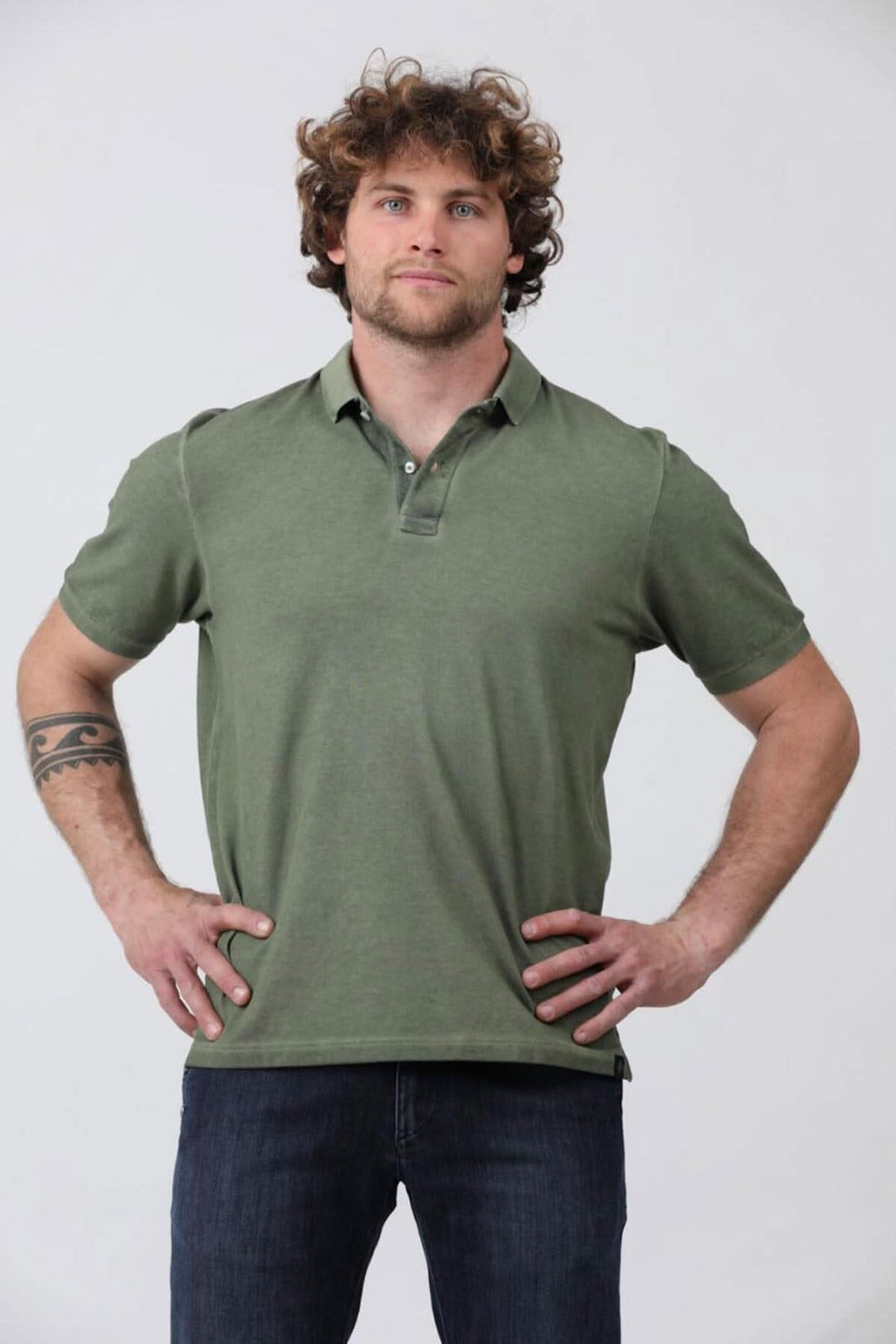 Homme portant un polo à manches courtes en jersey de coton piqué, couleur olive, avec des jeans.